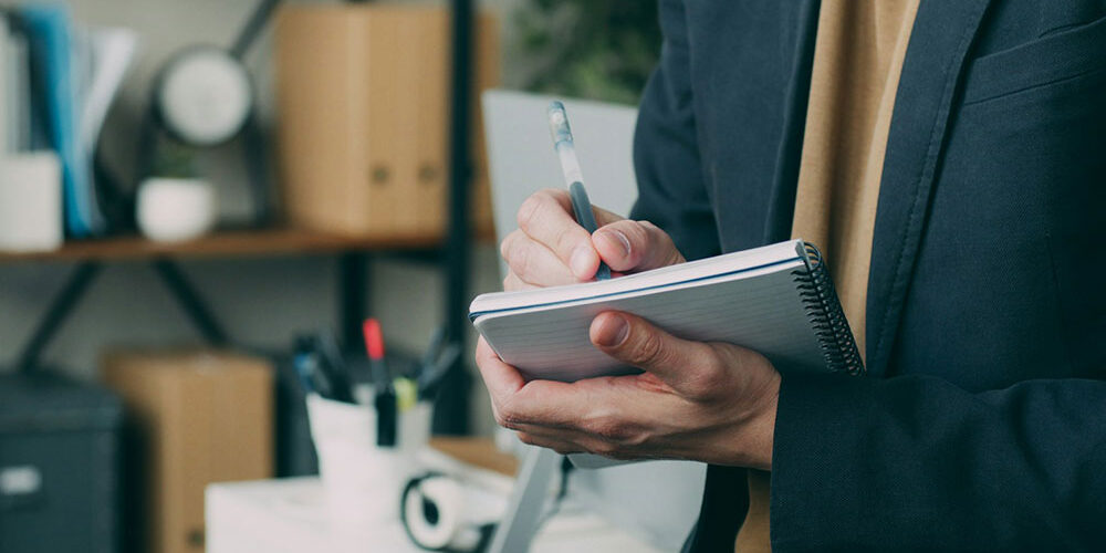 Business owner writing in a notebook in an office