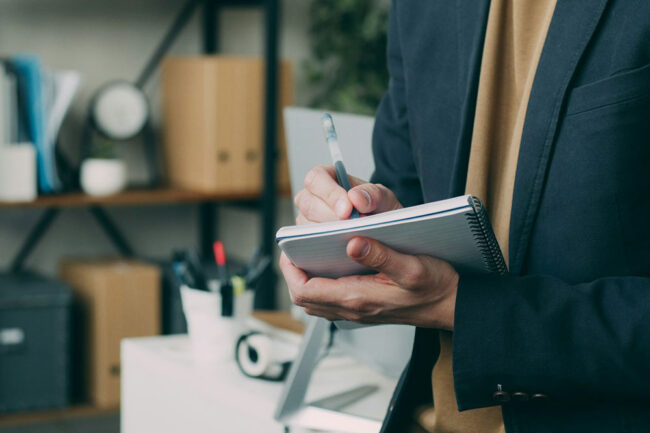 Business owner writing in a notebook in an office